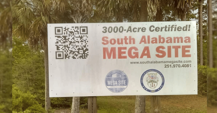 A white sign on wooden posts reads 3000-Acre Certified South Alabama MEGA SITE with a QR code, contact details, and the Baldwin County seal