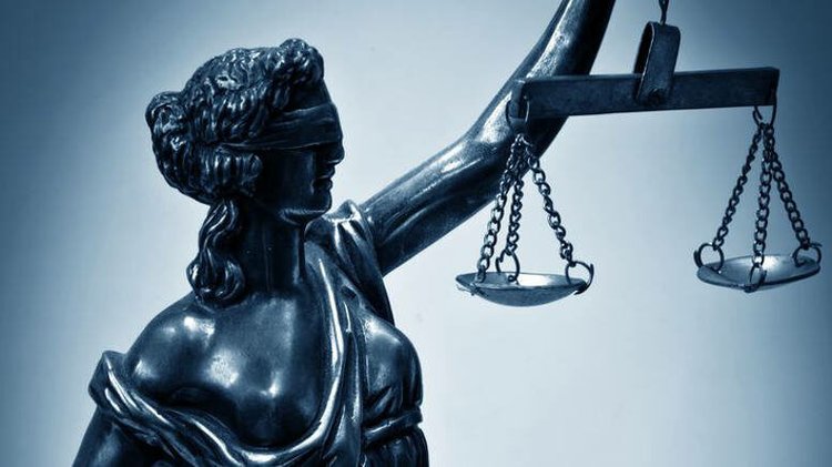 Statue of Justice holding scales against a dark background, representing concerns about Baldwin County Family Court practices