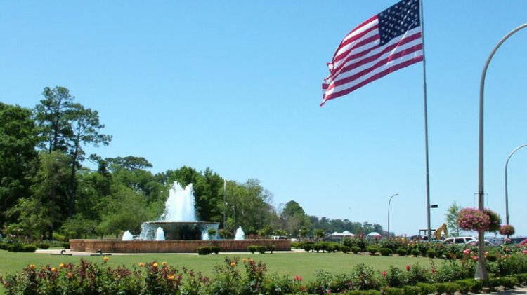 American flag waving over a fountain in Fairhope, Alabama, reflecting local voting patterns discussed in the article