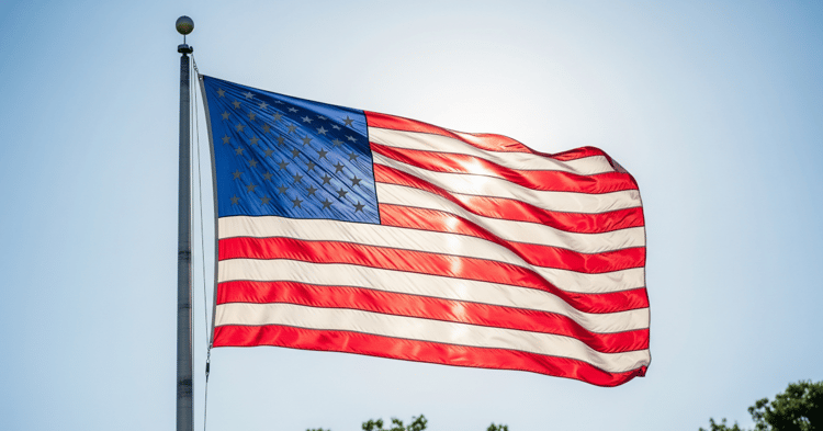 American flag waving against a blue sky, symbolizing military service and oaths of allegiance to defend the nation