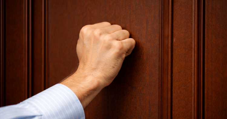 Door knocker on a weathered door, symbolizing persistent effort needed for success despite potential rejection