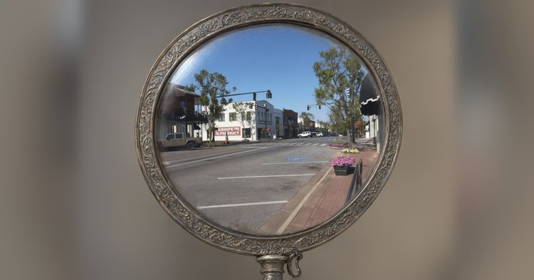 An ornate vintage hand mirror with a reflection of Fairhope.