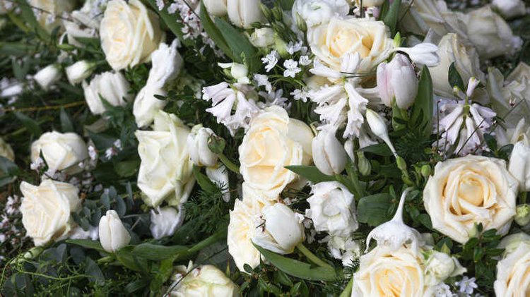 Floral tribute of white roses and lilies, a memento honoring the memory of dear friend Raymond Watkins