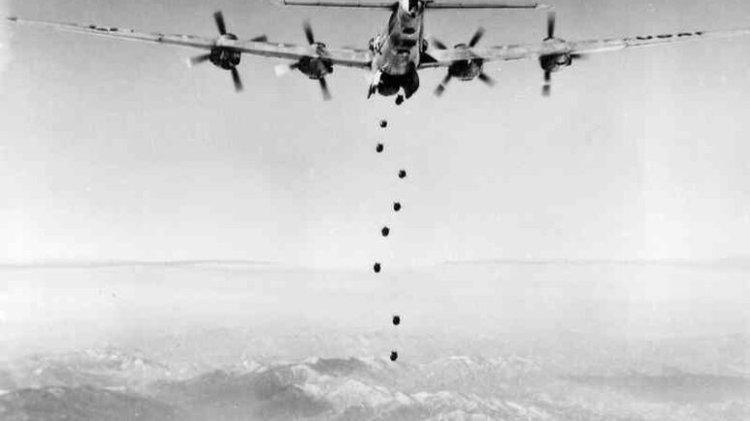 Vintage photo of a bomber dropping bombs over mountains, hinting at potential political fallout ahead of an election